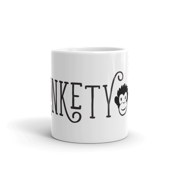 white mug with black and white MonketyBiz logo in curvy font including Monkety Monk face. View shows "NKETY" and the monkey's face. 